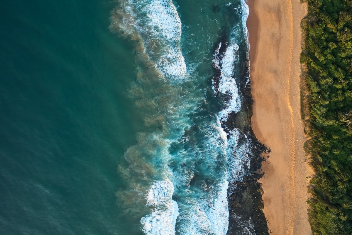 Quiet coastline beach with no people. There is a great flow of contrast between the ocean, the beach and the belt of green bush. Tongaat Huletts, Sibaya, Durban, Kwazulu Natal, South Africa