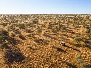 A private safari vehicle exploring the vast red-sand wilderness of Tswalu Kalahari in South Africa's Northern Cape